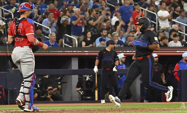 Toronto Blue Jays' Andres Gimenez (0) scores on a single by Bo Bichette against the Los Angeles Angels in sixth inning of a baseball game in Toronto, Friday, July 4, 2025. (Jon Blacker/The Canadian Press via AP)