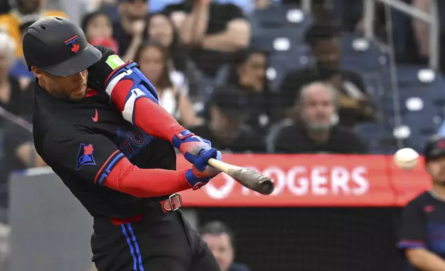 Toronto Blue Jays' George Springer (4) hits a single against the Los Angeles Angels in fourth inning of a baseball game in Toronto, Friday, July 4, 2025. (Jon Blacker/The Canadian Press via AP)