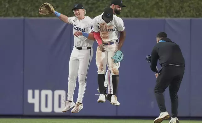 Miami Marlins left fielder Kyle Stowers, left, right fielder Jesus Sanchez, center, and center fielder Derek Hill, center, celebrate after the Marlins defeated the Minnesota Twins in a baseball game, Thursday, July 3, 2025, in Miami. (AP Photo/Lynne Sladky)