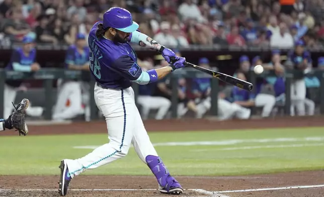 Arizona Diamondbacks' Eugenio Suárez connects for a run-scoring single against the Kansas City Royals during the third inning of a baseball game Saturday, July 5, 2025, in Phoenix. (AP Photo/Ross D. Franklin)