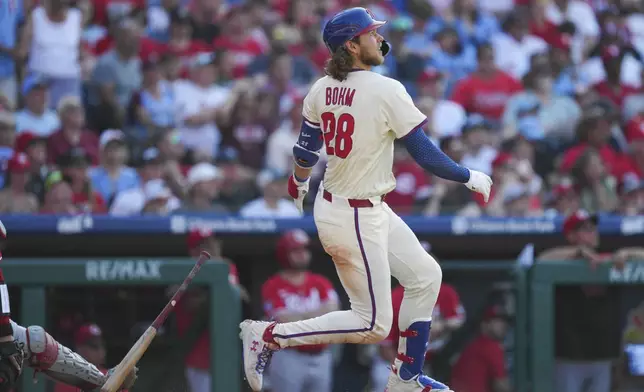 Philadelphia Phillies' Alec Bohm watches his two-run home run off Cincinnati Reds pitcher Nick Lodolo during the sixth inning of a baseball game, Saturday, July 5, 2025, in Philadelphia. (AP Photo/Derik Hamilton)