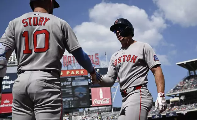 Boston Red Sox's Romy Gonzalez, right, is greeted by Trevor Story after he scored on a double by Rob Refsnyder during the first inning of a baseball game against the Washington Nationals, Saturday, July 5, 2025, in Washington. (AP Photo/Nick Wass)