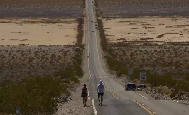 Danny Westergaard, right, competes with pacing help from daughter Meagan Westergaard during the Badwater 135 Ultramarathon, Tuesday, July 8, 2025, in Death Valley National Park, Calif. (AP Photo/John Locher)