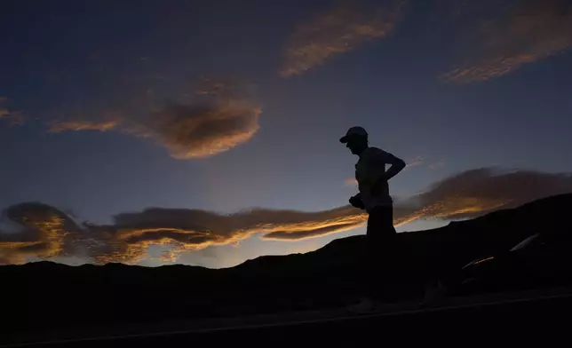 Danny Westergaard runs as the sun rises during the Badwater 135 Ultramarathon, Wednesday, July 9, 2025, near Lone Pine, Calif. (AP Photo/John Locher)