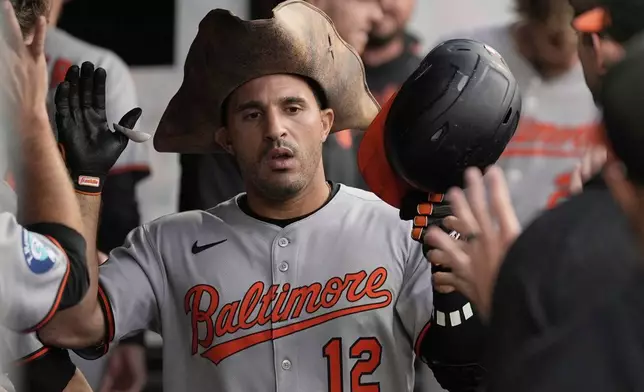 Baltimore Orioles' Ramon Laureano (12) is congratulated in the dugout after hitting a home run in the sixth inning of a baseball game against the Cleveland Guardians in Cleveland, Tuesday, July 22, 2025. (AP Photo/Sue Ogrocki)