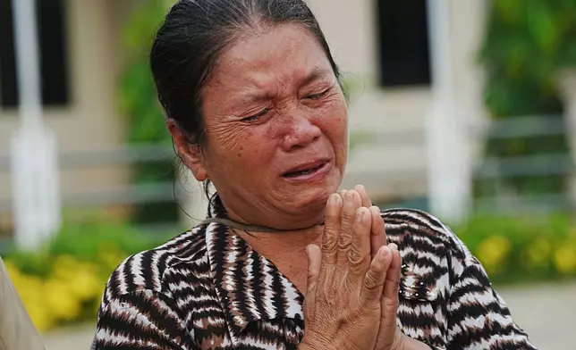 A local villager weeps as she donates her personal belongings for the frontline army force at a sidewalk in Srey Snam district in Siem Reap province, Cambodia, Saturday, July 26, 2025. (AP Photo/Heng Sinith)