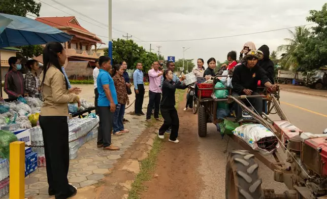 A tractor of refugees recieve donated supplies from the Srel Snam District Office as they flee the ongoing border conflict between Thailand and Cambodia in Oddar Meanchey Province, Cambodia on Saturday, July 26, 2025. (AP Photo/Anton L. Delgado)