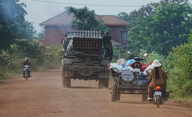 Cambodians drive behind a military vehicle for evacuation in Oddar Meanchey province, Cambodia, Friday, July 25, 2025, as Thai and Cambodian soldiers have clashed along the border between their countries in a major escalation. (AP Photo/Heng Sinith)