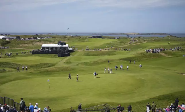 A group of players including Rickie Fowler of the United States walk onto the 14th green ring a practice round for the British Open golf championship at the Royal Portrush Golf Club, Northern Ireland, Wednesday, July 16, 2025. (AP Photo/Jon Super)