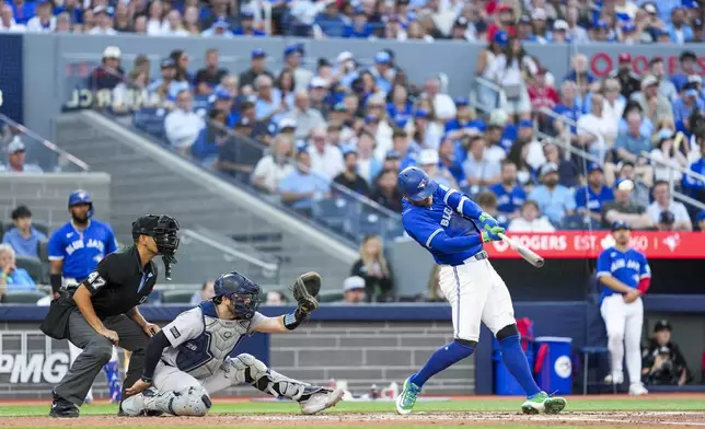 Toronto Blue Jays' George Springer (4) hits a two-run home run against the New York Yankees during third inning MLB baseball action, in Toronto on Thursday, July 3, 2025. (Thomas Skrlj/The Canadian Press via AP)