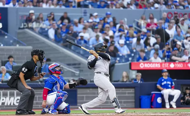New York Yankees' Trent Grisham (12) hits a solo home run against the Toronto Blue Jays during third inning MLB baseball action, in Toronto on Thursday, July 3, 2025. (Thomas Skrlj/The Canadian Press via AP)