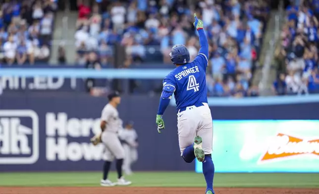 Toronto Blue Jays' George Springer (4) celebrates his two-run home run against the New York Yankees during third inning MLB baseball action, in Toronto on Thursday, July 3, 2025. (Thomas Skrlj/The Canadian Press via AP)