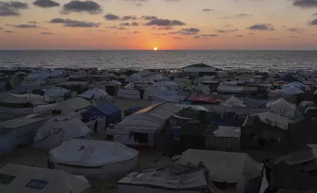 A tent camp for displaced Palestinians stretches near the shore during the sunset in Khan Younis, Gaza Strip, Wednesday, July 2, 2025. (AP Photo/Abdel Kareem Hana)