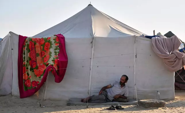 A Palestinian, Adham Sabah, 39, lies outside a tent at a camp for displaced people in Khan Younis, Gaza Strip, Wednesday, July 2, 2025. (AP Photo/Abdel Kareem Hana)