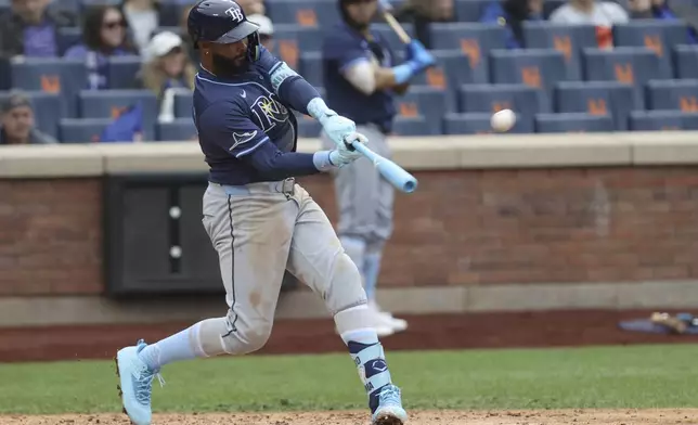 FILE - Tampa Bay Rays' Junior Caminero hits a home run, leading Taylor Walls and Brandon Lowe to score, during the ninth inning of a baseball game against the New York Mets, Sunday, June 15, 2025, in New York. (AP Photo/Pamela Smith, File)