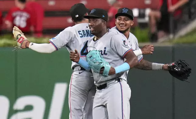 Miami Marlins' Javier Sanoja, left, Jesus Sanchez and Dane Myers, right, celebrate a victory over the St. Louis Cardinals in a baseball game Wednesday, July 30, 2025, in St. Louis. (AP Photo/Jeff Roberson)