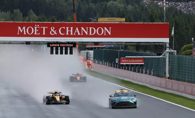 McLaren driver Lando Norris of Britain and McLaren driver Oscar Piastri of Australia steer their cars behind the safety vehicle at the start of the Formula One Grand Prix at the Spa-Francorchamps racetrack in Spa, Belgium, Sunday, July 27, 2025. (AP Photo/Geert Vanden Wijngaert)