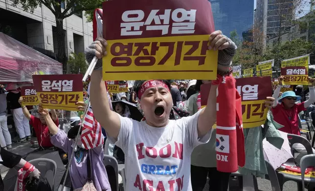 Supporters of former South Korean President Yoon Suk Yeol holds aloft a banner during a rally against a hearing to review a special prosecutor's request for his arrest near the Seoul Central District Court in Seoul, South Korea, Wednesday, July 9, 2025. The letters read "Yoon Suk Yeol's warrant rejected." (AP Photo/Ahn Young-joon)