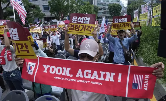 Supporters of former South Korean President Yoon Suk Yeol stage a rally against a hearing to review a special prosecutor's request for his arrest near the Seoul Central District Court in Seoul, South Korea, Wednesday, July 9, 2025. The letters on banners, seen rear, read "Yoon Suk Yeol's warrant rejected." (AP Photo/Ahn Young-joon)