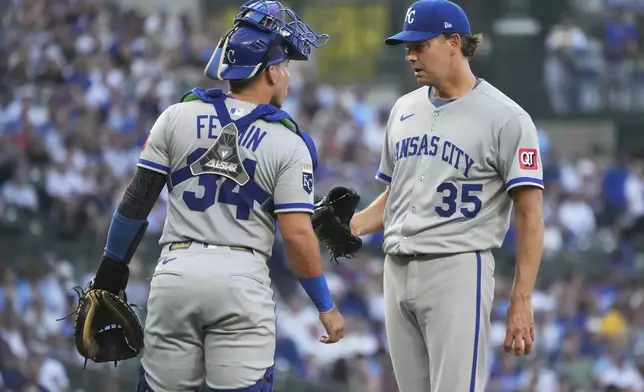 Kansas City Royals catcher Freddy Fermin, left, talks with starting pitcher Rich Hill during the first inning of a baseball game against the Chicago Cubs in Chicago, Tuesday, July 22, 2025. (AP Photo/Nam Y. Huh)