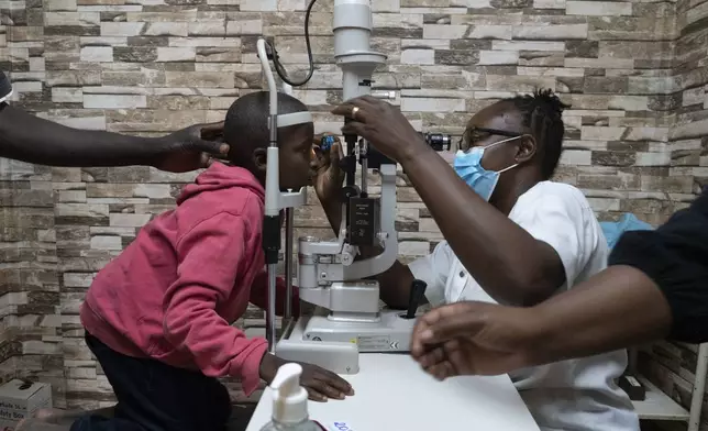 Dr. Claudette Yaméogo, Burkina Faso's only ophthalmologist specializing in treating children, checks Isaka Diallo who has lost vision in his left eye at the Sanou Sourou University Hospital in the city of Bobo-Dioulasso, Burkina Faso, Thursday, June 5, 2025. (AP Photo/Elia Borras)