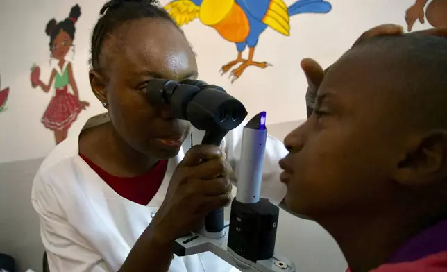 Dr. Claudette Yaméogo, Burkina Faso's only ophthalmologist specializing in treating children, checks Isaka Diallo who has lost vision in his left eye at the Sanou Sourou University Hospital in the city of Bobo-Dioulasso, Burkina Faso, Thursday, June 5, 2025. (AP Photo/Elia Borras)