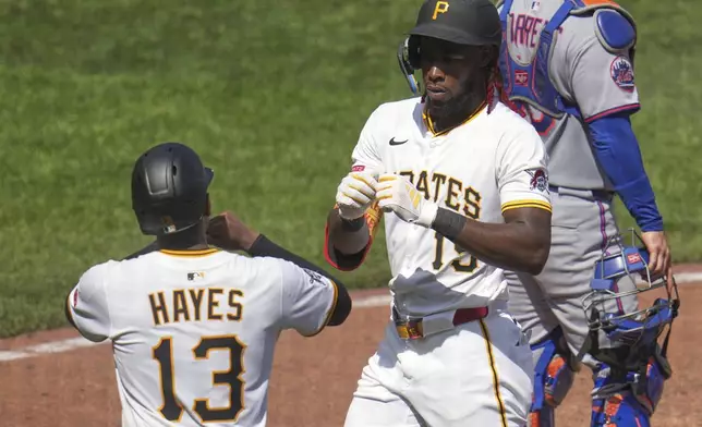 Pittsburgh Pirates' Oneil Cruz, center, celebrates with Ke'Bryan Hayes (13) after both scored on his two-run home run off New York Mets pitcher Dedniel Núñez during the seventh inning of a baseball game in Pittsburgh, Sunday, June 29, 2025. (AP Photo/Gene J. Puskar)