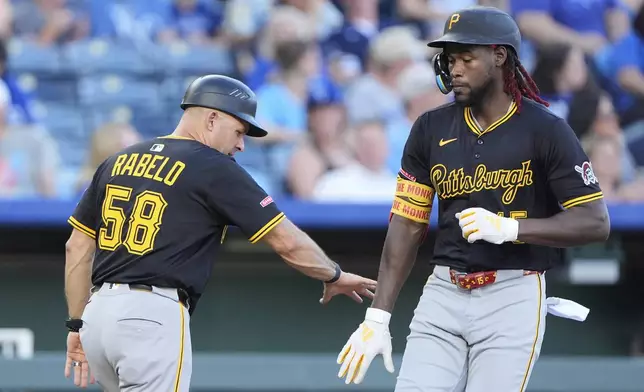 Pittsburgh Pirates' Oneil Cruz celebrates with third base coach Mike Rabelo (58) after hitting a solo home run during the fourth inning of a baseball game against the Kansas City Royals, Tuesday, July 8, 2025, in Kansas City, Mo. (AP Photo/Charlie Riedel)