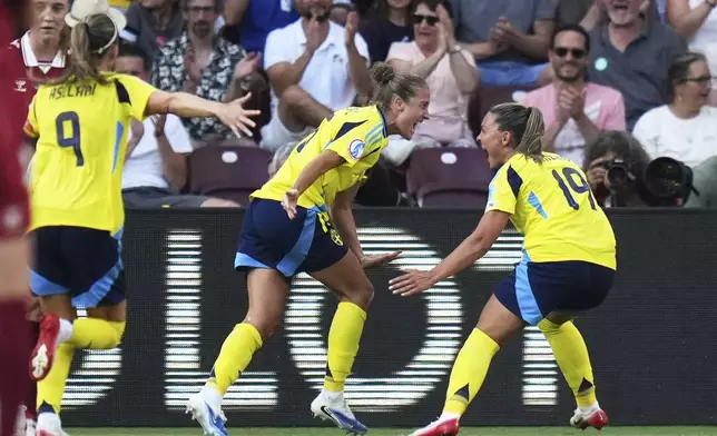 Sweden's Filippa Angeldahl celebrates with teammate Johanna Rytting Kaneryd, right, after scoring the opening goal during the Euro 2025, group C, soccer match between Denmark and Sweden at Stade de Geneve in Geneva, Switzerland, Friday, July 4, 2025. (AP Photo/Alessandra Tarantino)