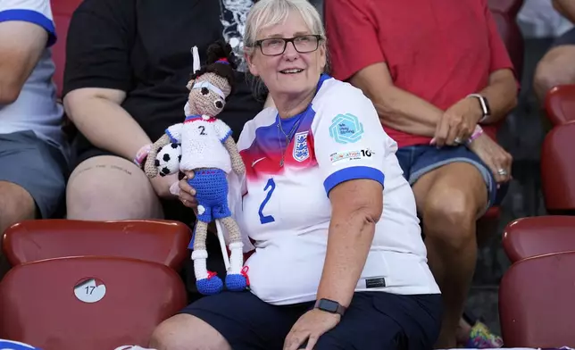A fan of England's Lucy Bronze holds a doll with her number 2 shirt on the stands before the Euro 2025, group D, soccer match between France and England at Stadion Letzigrund in Zurich, Switzerland, Saturday, July 5, 2025. (AP Photo/Martin Meissner)