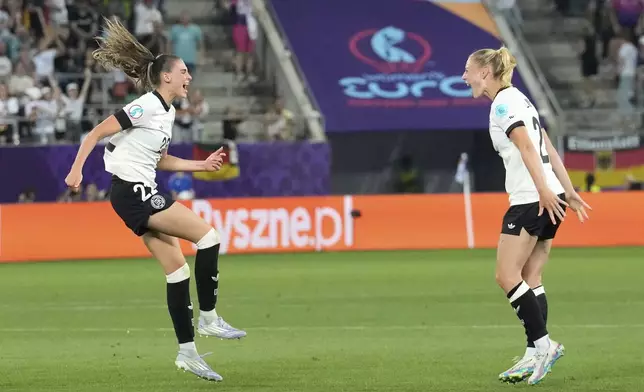 Germany's Jule Brand, left, celebrates with Sarai Linder after scoring the opening goal during the Euro 2025, group C, soccer match between Germany and Poland at Arena St. Gallen in St. Gallen, Switzerland, Friday, July 4, 2025. (AP Photo/Martin Meissner)