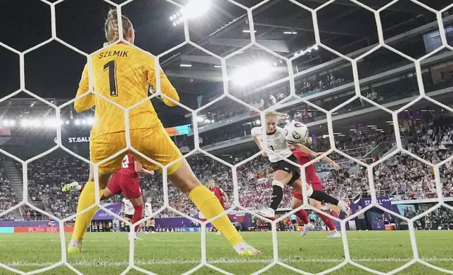 Germany's Lea Schueller, right, scores her side's second goal past Poland goalkeeper Kinga Szemik during the Euro 2025, group C, soccer match between Germany and Poland at Arena St. Gallen in St. Gallen, Switzerland, Friday, July 4, 2025. (AP Photo/Martin Meissner)
