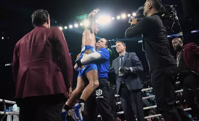 Mario Barrios, center, reacts after fighting to a majority draw against Manny Pacquiao in a welterweight title boxing match Saturday, July 19, 2025, in Las Vegas. (AP Photo/John Locher)