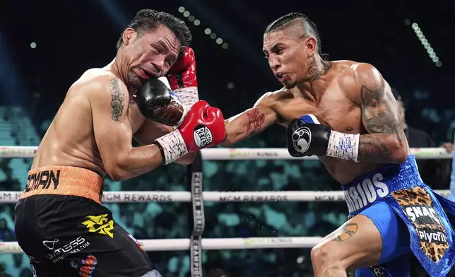 Manny Pacquiao, left, fights Mario Barrios in a welterweight title boxing match Saturday, July 19, 2025, in Las Vegas. (AP Photo/John Locher)