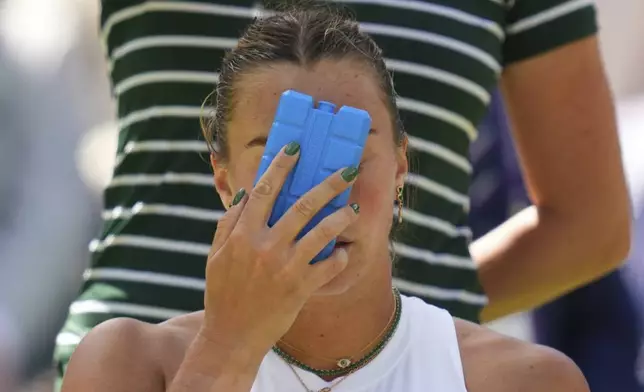 Aryana Sabalenka of Belarus tries to keep cool using an ice pack during a change of ends break as she plays Laura Siegemund of Germany during a quarterfinal women's singles match at the Wimbledon Tennis Championships in London, Tuesday, July 8, 2025. (AP Photo/Kirsty Wigglesworth)