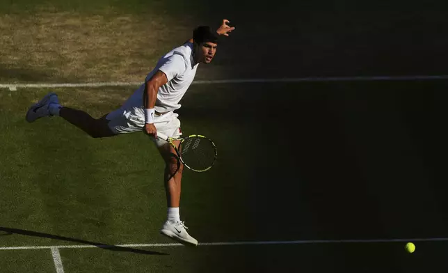 Spain's Carlos Alcaraz returns to Britain's Cameron Norrie during a quarterfinal men's singles match at the Wimbledon Tennis Championships in London, Tuesday, July 8, 2025. (AP Photo/Joanna Chan)