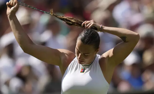 Aryna Sabalenka of Belarus adjusts her hair as she plays Amanda Anisimova of the U.S. during a women's singles semifinal match at the Wimbledon Tennis Championships in London, Thursday, July 10, 2025. (AP Photo/Kin Cheung)