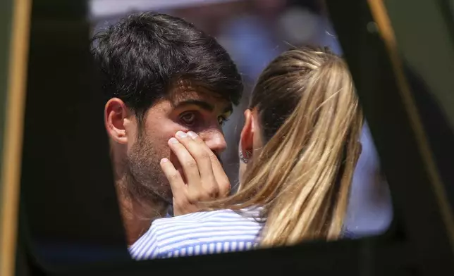 Spain's Carlos Alcaraz has his eye checked during a break in play against Taylor Fritz of the U.S. in a men's singles semifinal at the Wimbledon Tennis Championships in London, Friday, July 11, 2025. (AP Photo/Joanna Chan)