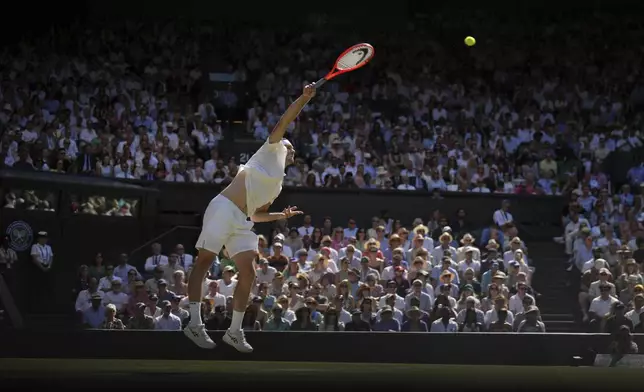 Taylor Fritz of the U.S. serves to Spain's Carlos Alcaraz in a men's singles semifinal at the Wimbledon Tennis Championships in London, Friday, July 11, 2025. (AP Photo/Kin Cheung)