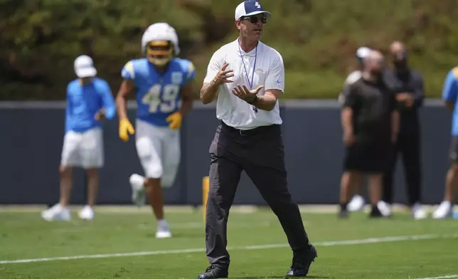 Los Angeles Chargers head coach Jim Harbaugh gestures as he works with players during an NFL football training camp session Tuesday, July 22, 2025, in San Diego. (AP Photo/Gregory Bull)