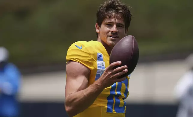 Los Angeles Chargers quarterback Justin Herbert smiles as he runs through a drill during an NFL football training camp Tuesday, July 22, 2025, in San Diego. (AP Photo/Gregory Bull)