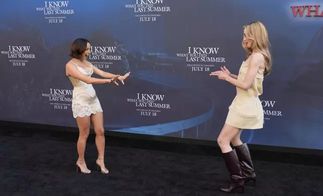 Chase Sui Wonders, left, and Sarah Pidgeon, cast members in "I Know What You Did Last Summer," greet each other on the carpet at the premiere of the film at The United Theater on Broadway, Monday, July 14, 2025, in Los Angeles (AP Photo/Chris Pizzello)