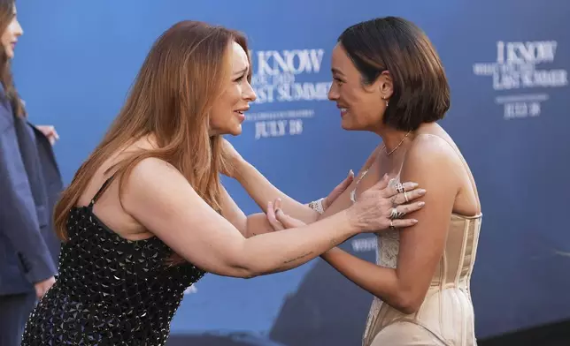 Jennifer Love Hewitt, left, and Chase Sui Wonders, cast members in "I Know What You Did Last Summer," greet each other at the premiere of the film at The United Theater on Broadway, Monday, July 14, 2025, in Los Angeles (AP Photo/Chris Pizzello)
