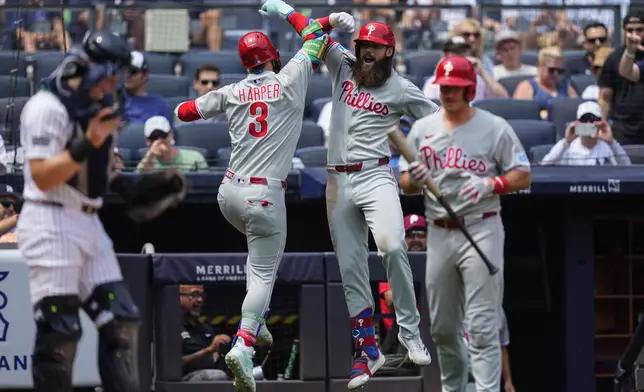 Philadelphia Phillies' Bryce Harper (3) and' Brandon Marsh (16) celebrate after Harper hit a home run during the third inning of a baseball game against the New York Yankees, Saturday, July 26, 2025, in New York. (AP Photo/Yuki Iwamura)