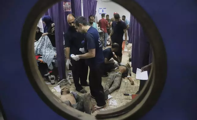 Palestinians who were injured during a food distribution at a center run by the Gaza Humanitarian Foundation, a U.S.-backed organization approved by Israel, receive treatment on the floor of Nasser Hospital in Khan Younis, southern Gaza Strip, Saturday, July 19, 2025. (AP Photo/Mariam Dagga)