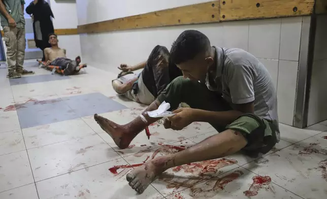 A Palestinian man who was injured during a food distribution at a center run by the Gaza Humanitarian Foundation, a U.S.-backed organization approved by Israel, waits for treatment on the floor of Nasser Hospital in Khan Younis, southern Gaza Strip, Saturday, July 19, 2025. (AP Photo/Mariam Dagga)