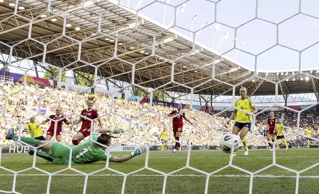Sweden's Filippa Angeldahl , background left, scores the opening goal during the Euro 2025, group C, soccer match between Denmark and Sweden at Stade de Geneve in Geneva, Switzerland, Friday, July 4, 2025. (Salvatore Di Nolfi/Keystone via AP)