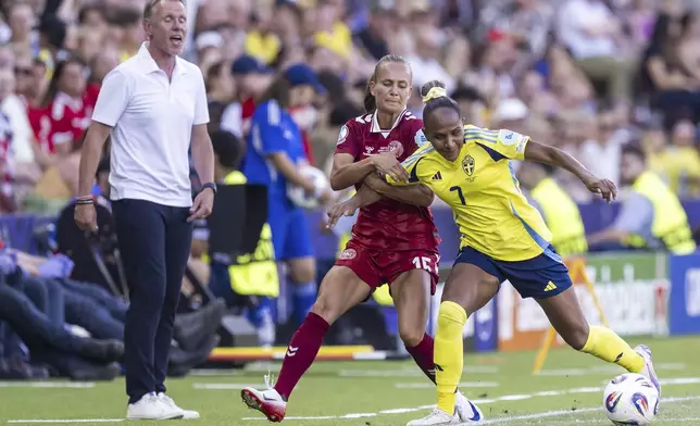 Denmark's Frederikke Thogersen, left, fights for the ball against Sweden's Madelen Janogy during the UEFA Women's EURO 2025 Group C soccer match between Denmark and Sweden at the Stade de Geneve stadium in Geneva, Switzerland, Friday, July 4, 2025. (Martial Trezzini/Keystone via AP)