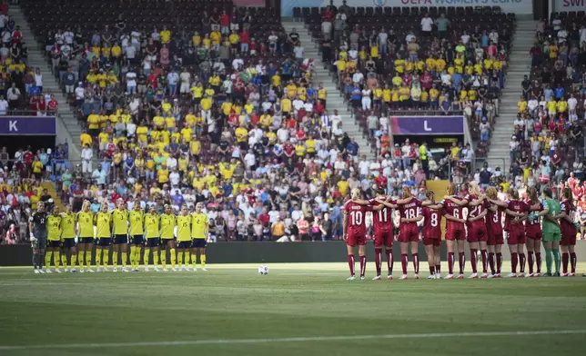 Players of the two teams observe a minute of silence in memory of Portugal international and Liverpool player Diogo Jota and his brother Andre Silva, before the Euro 2025, group C, soccer match between Denmark and Sweden at Stade de Geneve in Geneva, Switzerland, Friday, July 4, 2025. (AP Photo/Alessandra Tarantino)