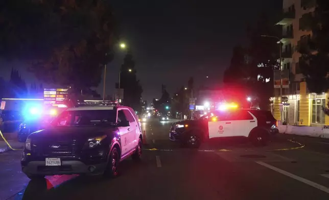 Police patrol vehicles close Vermiont Ave. after a vehicle rammed into a crowd gathered outside "The Vermont" nightclub in Los Angeles, early morning Saturday, July 19, 2025. (AP Photo/Damian Dovarganes)